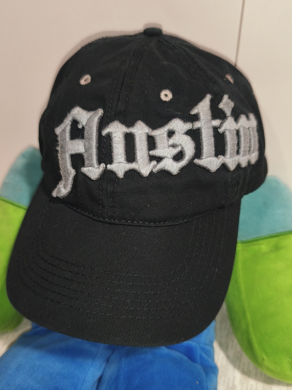OG Austin black cap featuring silver Old English embroidery across the front.